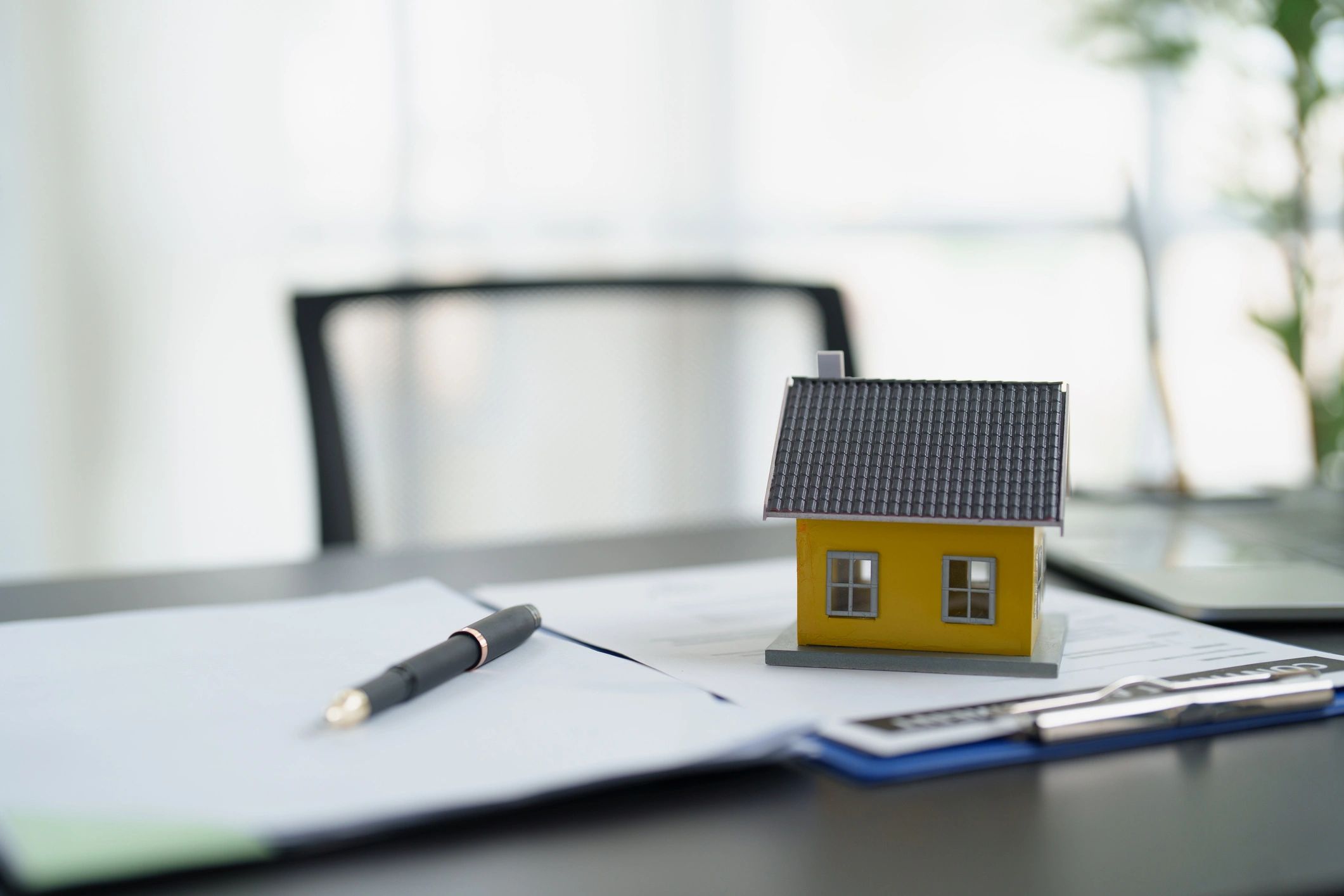 Model house on real estate documents representing leasing administration